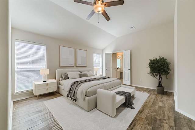 bedroom with visible vents, baseboards, lofted ceiling, and wood finished floors