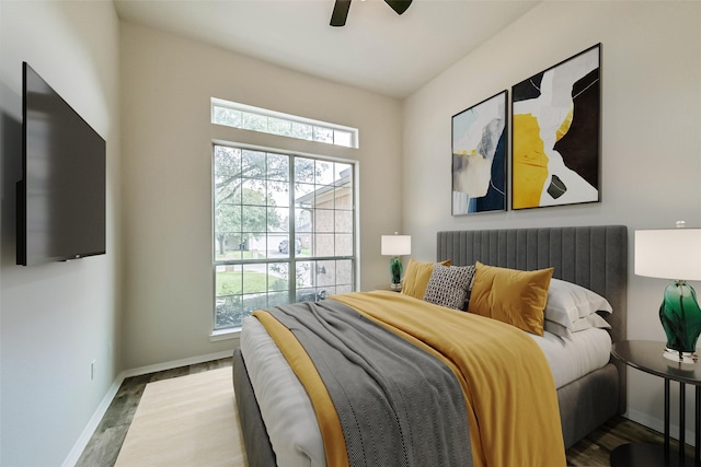 bedroom with baseboards, multiple windows, radiator, and wood finished floors