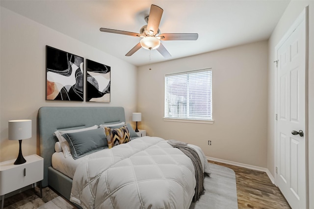 bedroom with ceiling fan, baseboards, and wood finished floors