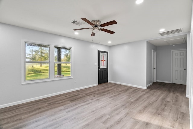 interior space featuring attic access, light wood-style floors, visible vents, and baseboards