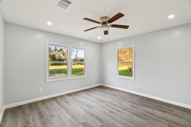 spare room with recessed lighting, visible vents, baseboards, and wood finished floors