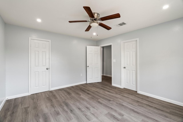 unfurnished bedroom featuring visible vents, wood finished floors, recessed lighting, baseboards, and ceiling fan