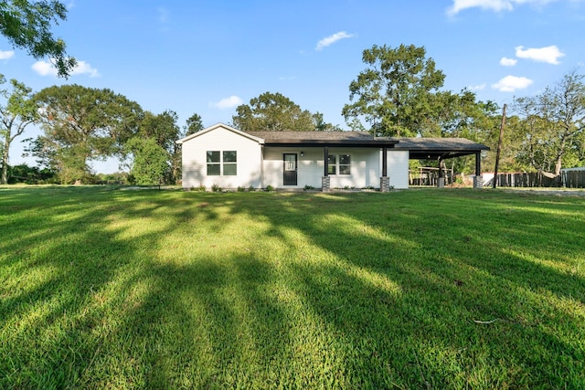 rear view of property with a lawn and fence