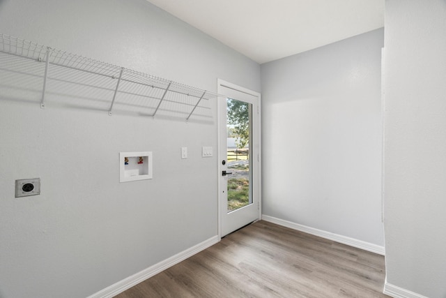 clothes washing area featuring wood finished floors, baseboards, hookup for an electric dryer, hookup for a washing machine, and laundry area