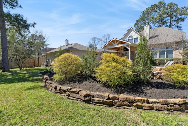 view of front of home with a front lawn, a chimney, and fence