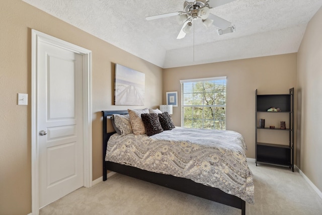 bedroom with baseboards, visible vents, vaulted ceiling, a textured ceiling, and light colored carpet