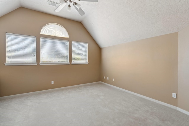 additional living space with a textured ceiling, lofted ceiling, a ceiling fan, and carpet floors