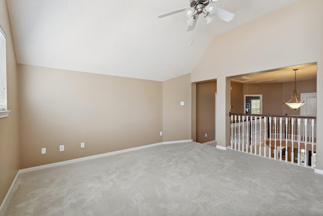 unfurnished room featuring carpet flooring, baseboards, a ceiling fan, and vaulted ceiling