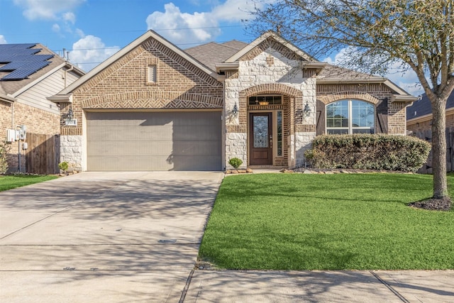 french country home with brick siding, a front yard, a garage, stone siding, and driveway