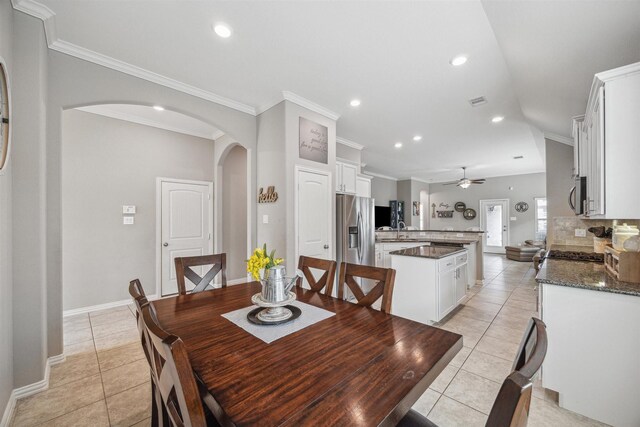 dining space featuring recessed lighting, arched walkways, crown molding, light tile patterned floors, and baseboards