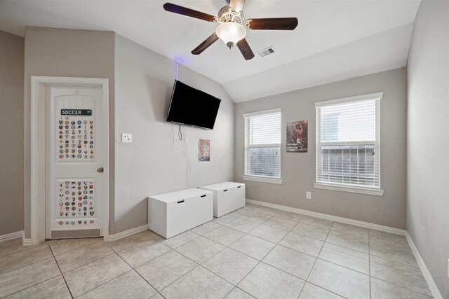 interior space featuring visible vents, a ceiling fan, baseboards, light tile patterned floors, and lofted ceiling