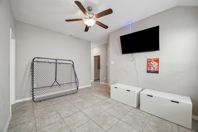 interior space with light tile patterned flooring, baseboards, lofted ceiling, and a ceiling fan