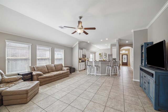 living area featuring ornamental molding, arched walkways, light tile patterned flooring, lofted ceiling, and ceiling fan