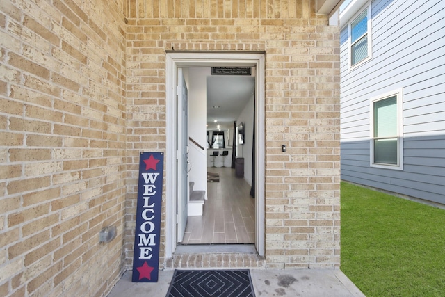 doorway to property with brick siding