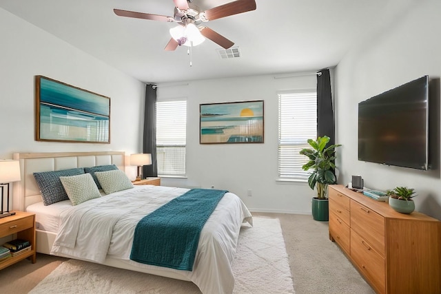 bedroom featuring visible vents, baseboards, light colored carpet, and ceiling fan