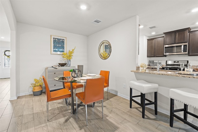 dining space with wood finish floors, visible vents, baseboards, and recessed lighting