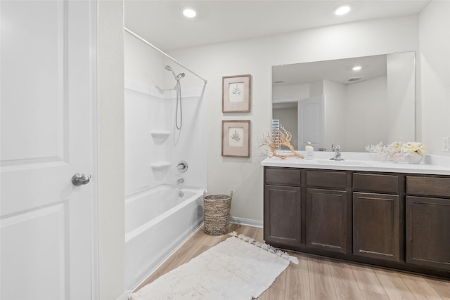 full bath with vanity, recessed lighting, wood finished floors, and bathtub / shower combination