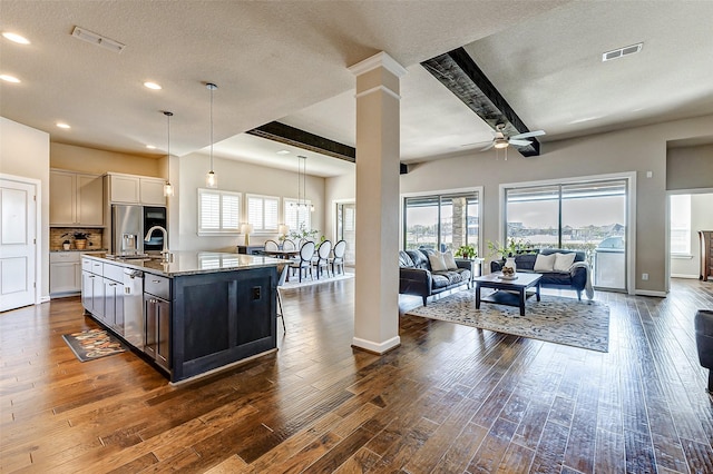 kitchen with visible vents, a sink, open floor plan, ceiling fan, and dark wood-style flooring