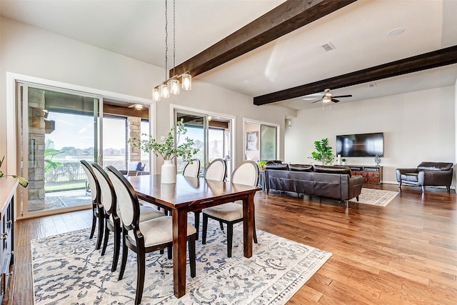 dining area featuring visible vents, beam ceiling, hardwood / wood-style floors, and a ceiling fan