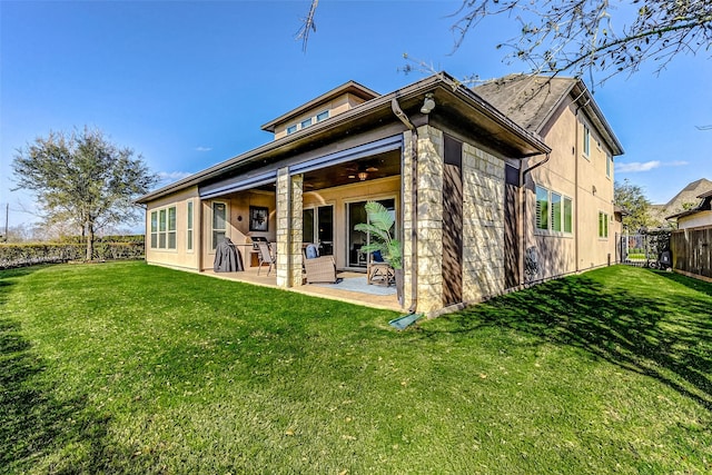 rear view of property featuring a patio area, ceiling fan, a yard, and fence