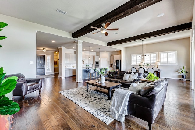 living room with dark wood-style floors, visible vents, beam ceiling, decorative columns, and ceiling fan