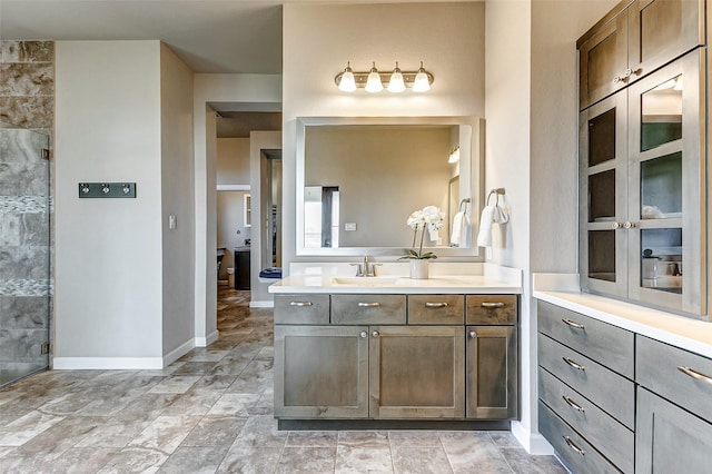 bathroom featuring vanity, baseboards, and a tile shower