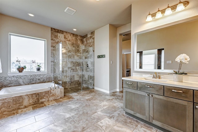 bathroom with visible vents, baseboards, walk in shower, a garden tub, and vanity