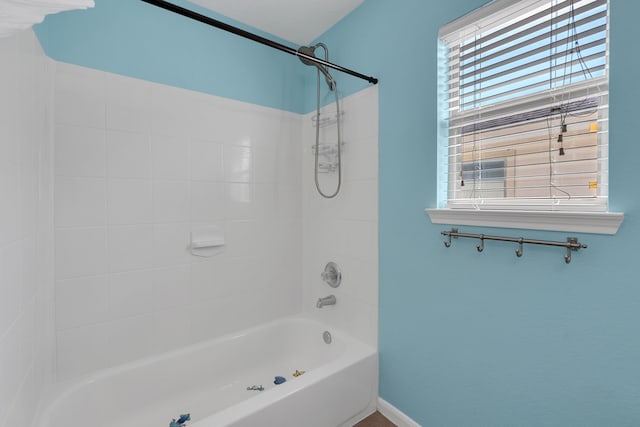 full bath featuring tub / shower combination and baseboards