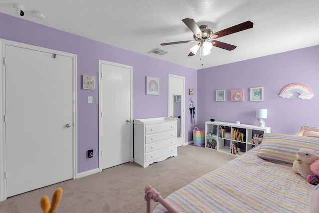 bedroom featuring visible vents, light carpet, a ceiling fan, a textured ceiling, and baseboards