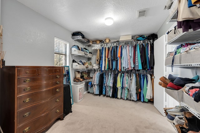 walk in closet featuring visible vents and light colored carpet