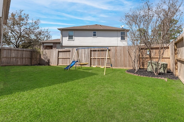 rear view of house with a lawn and a fenced backyard