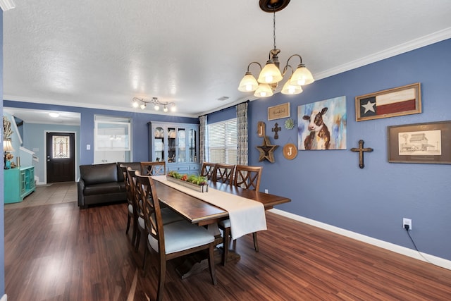 dining space featuring baseboards, wood finished floors, a chandelier, and crown molding