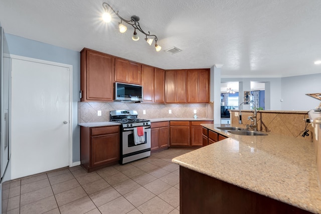 kitchen with backsplash, visible vents, appliances with stainless steel finishes, and a sink