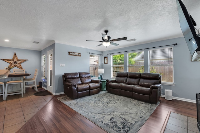 living area featuring crown molding, wood finished floors, visible vents, and ceiling fan