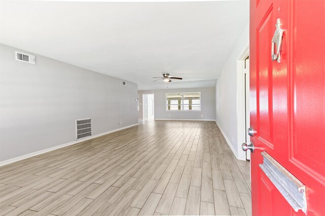 foyer with a ceiling fan, visible vents, light wood finished floors, and baseboards