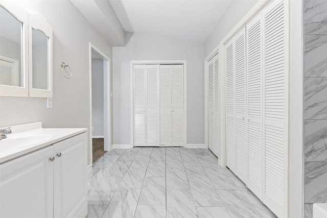 full bathroom with vanity, a closet, and marble finish floor