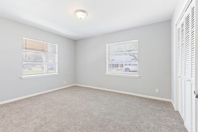 unfurnished bedroom featuring carpet, a closet, and baseboards