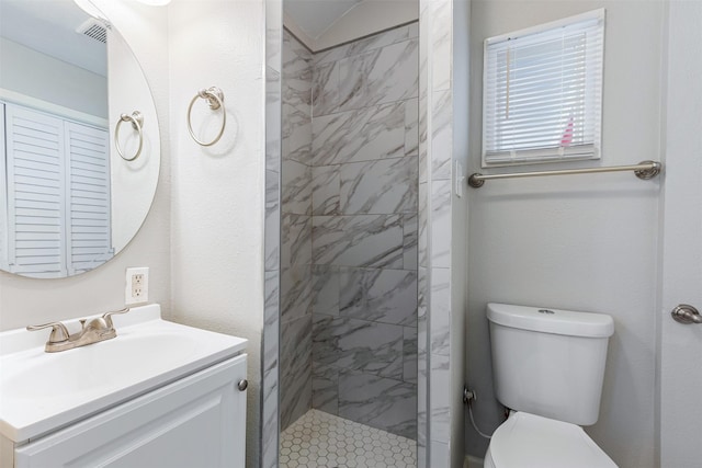 bathroom featuring tiled shower, toilet, and vanity