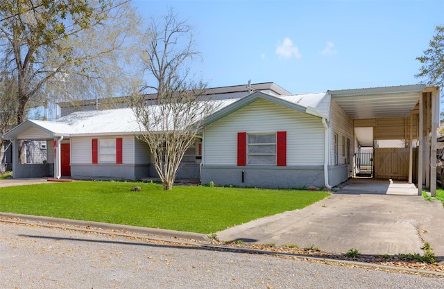 view of front facade with metal roof, an attached carport, concrete driveway, and a front lawn