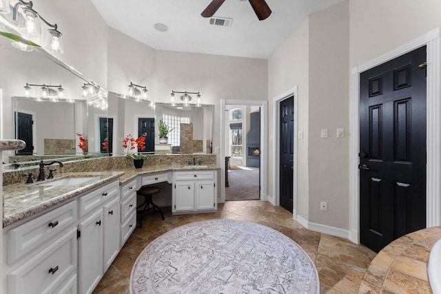 bathroom featuring double vanity, visible vents, a ceiling fan, and a sink