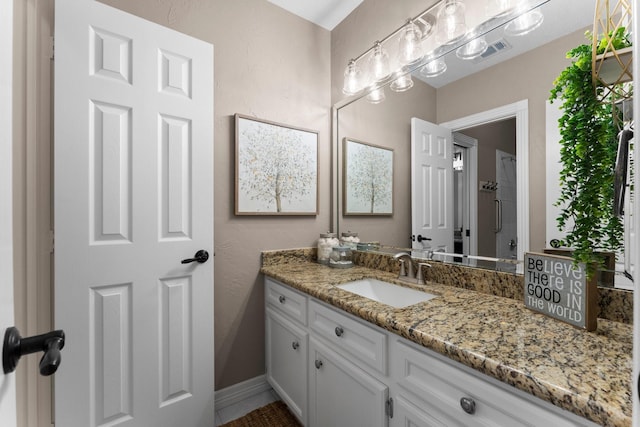 bathroom featuring visible vents, vanity, and baseboards