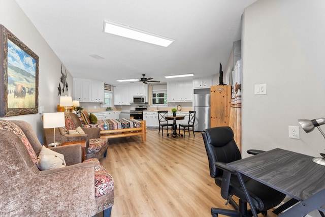 living room with ceiling fan and light wood-style flooring