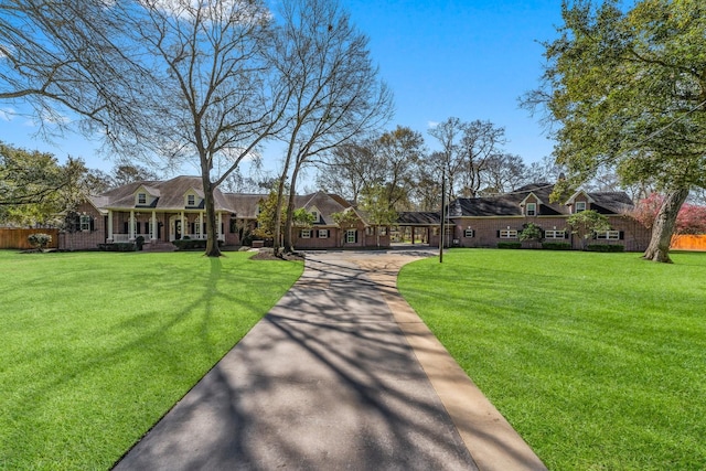 view of front of house with a porch, a front yard, and fence