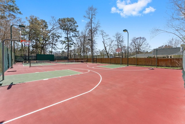 view of basketball court featuring a tennis court, community basketball court, and fence