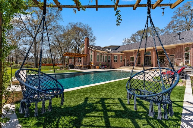 pool featuring a patio, a yard, and a pergola