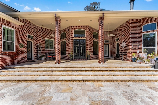 doorway to property with french doors, a patio, and brick siding