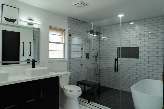 full bathroom featuring a freestanding tub, visible vents, toilet, a stall shower, and vanity