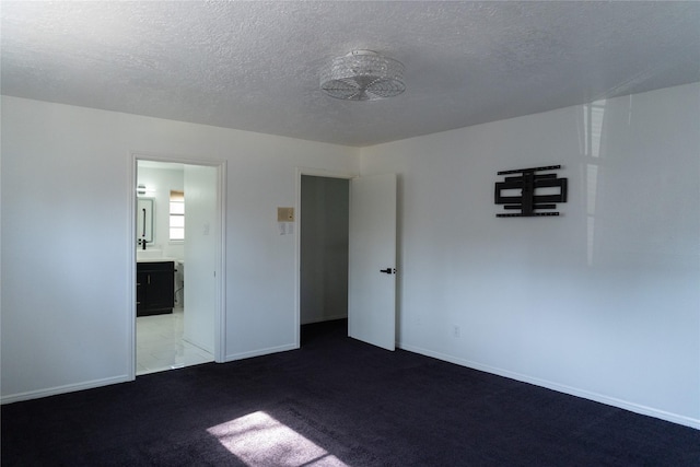 spare room with baseboards, a textured ceiling, and carpet flooring