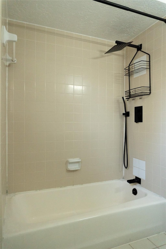 full bath featuring tile patterned floors, a textured wall, shower / bathtub combination, and a textured ceiling