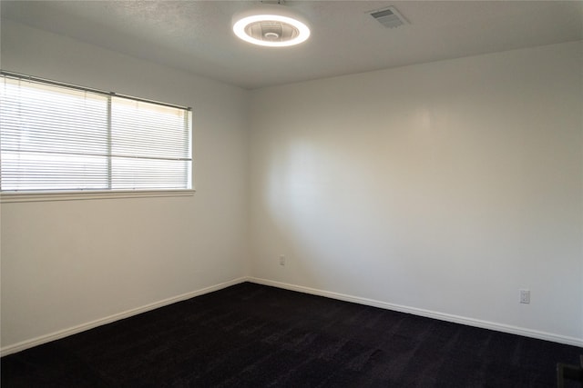 unfurnished room featuring visible vents and baseboards